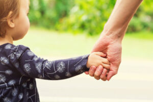 Nature vs nurture - child holding an adults hand.